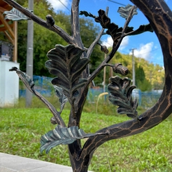 Detail of an oak twig on the wrought iron railing at the entrance to the family house Detail of an oak twig on the wrought iron railing at the entrance to the family house