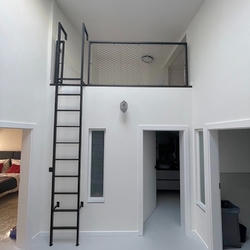 The use of space in high rooms will be ensured by a modern metal railing with a ladder