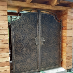 Kovaná brána vsadená do dreveného prístrešku