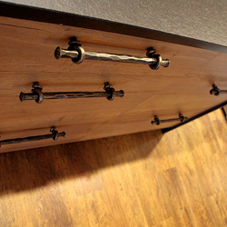 Forged handles on kitchen cabinet - detailed view on wrought iron work