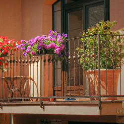 Kované zábradlie s držiakmi kvetov na balkóne rodinného domu