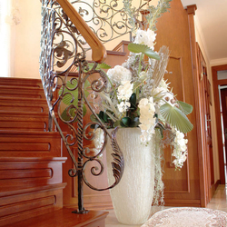 A wrought iron staircase railing with a wooden handrail