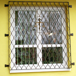 Hand-forged scales – a symbol of medicine – on the grilles of a pharmacy