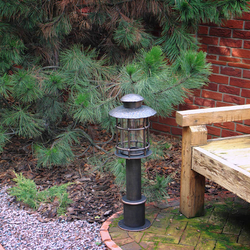 A wrought iron standard lamp in a garden