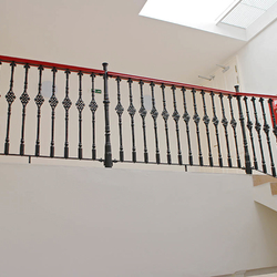 Interior cast iron railings with a wooden handrail