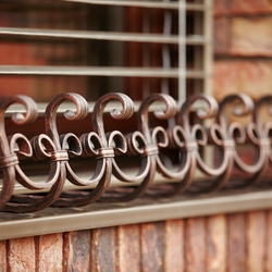 Forged flower pot holders on the windows of a family house