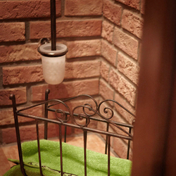 A wrought iron toilet brush holder