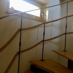 Kované zábradlie s lanom na interiérovom točitom schodisku 