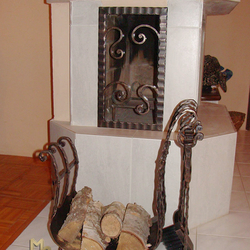 A wrought iron firewood rack with fireplace tools