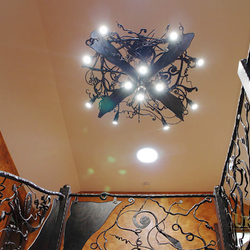 A wrought iron bat above a gallery - an eye-catching chandelier
