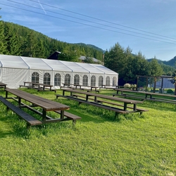 Garden tables and benches on a grassy area for visitors to relax and dine Garden tables and benches on a grassy area for visitors to relax and dine