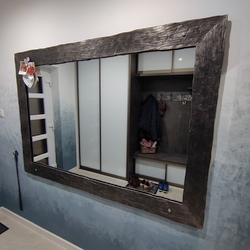 Modern forged, polished and varnished mirror in a family house hall