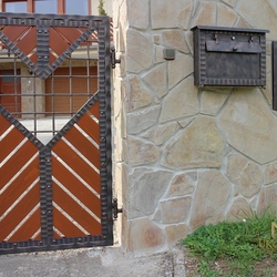 A modern post box in harmony with a fence