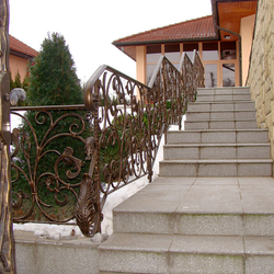 A wrought iron railing - stairs in a garden