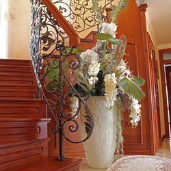 A wrought iron railing with a wooden handrail