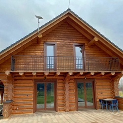 Wrought iron railing on the balcony of a log house - exterior railing