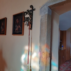 Kovaný držiak na zvon pri dverách v kostole